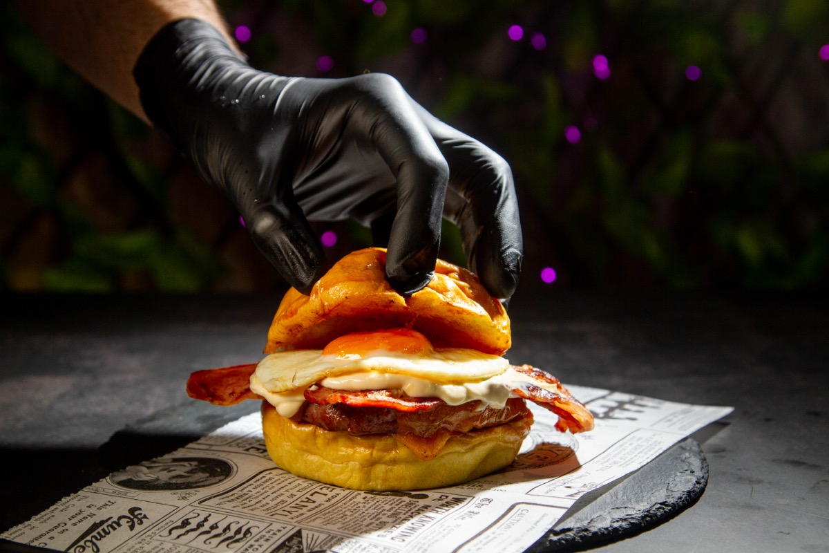 Hamburguesa D&M abierta con guante negro